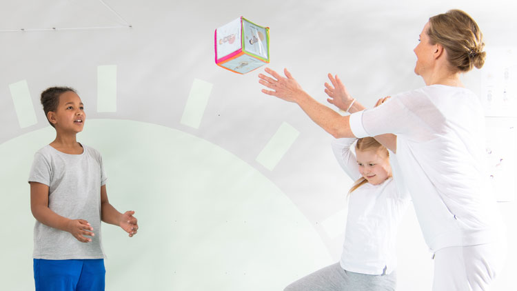 Pädagogin wirft Kindern den Pocket Cube zu