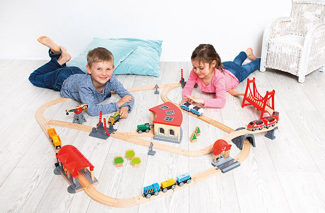 Kinder spielen mit Holzeisenbahn