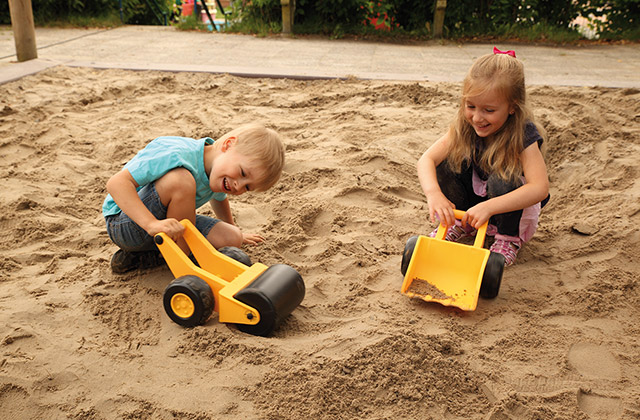 Kinder spielen mit Sandspielzeug im Sandkasten